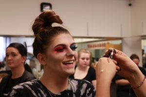 Model laughs while her makeup is applied